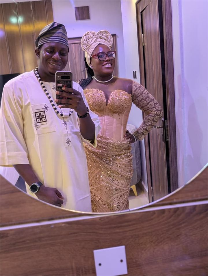 Osaro and Achi taking a mirror selfie in traditional attire